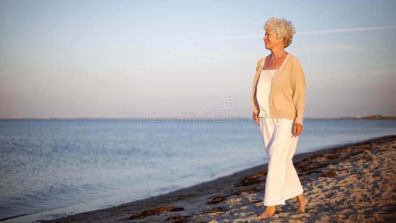 Anziana cammina sulla spiaggia per l'ultima volta