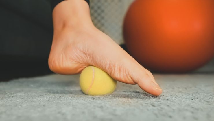 Pallina da tennis sotto il piede